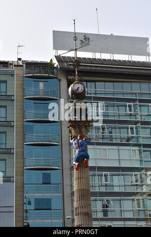 Figurine Spider-Man grimpant un obélisque avec une horloge et une girouette. A Coruña Comic-con, Espagne. Banque D'Images