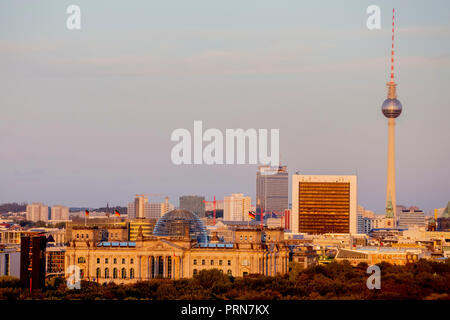 03 octobre 2018, Berlin : le soleil du soir brille sur le Reichstag (devant) et la tour de télévision de Berlin. Photo : Christoph Soeder/dpa Banque D'Images