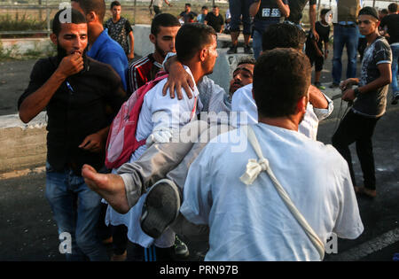 La bande de Gaza. 3e oct, 2018. Les médecins palestiniens transporter un blessé lors d'affrontements avec des soldats israéliens au point de passage d'Erez, près de la frontière avec Israël, dans le nord de la bande de Gaza, le 3 octobre 2018. Les soldats israéliens stationnés à la frontière avec le nord de la bande de Gaza tué mercredi soir un adolescent palestinien au cours d'affrontements avec des dizaines de manifestants palestiniens, médecins dit. Source : Xinhua/Alamy Live News Banque D'Images