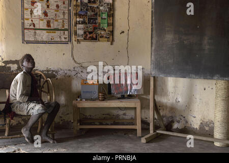 3 mai 2017 - lac Eyasi, district de Ngorongoro, en Tanzanie - Oussama, 14 ans, entre dans une école pour la première fois dans sa vie. Il a l'air étonné de l'environnement et les éléments aux murs.Les Hadza sont l'une des dernières sociétés, qui restent dans le monde, que survivre uniquement à partir de la chasse et de la cueillette. Très peu de choses ont changé dans la façon dont les Hadzas vivent leur vie. Mais il est devenu plus difficile pour eux de poursuivre les Hadza mode de vie. Soit les Hadza trouveront un moyen de sécuriser leur terre-homme d'avoir accès à des sources d'eau non polluée et les animaux sauvages, ou les Hadza Banque D'Images