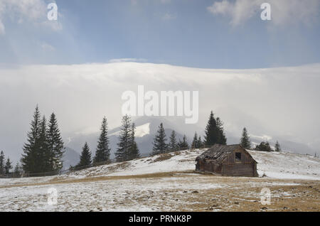 Paysage de printemps avec de petites maisons en bois pour le foin. Carpates, l'Ukraine, l'Europe Banque D'Images