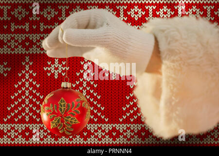 Image composite de santas main est tenant une ampoule de Noël Banque D'Images