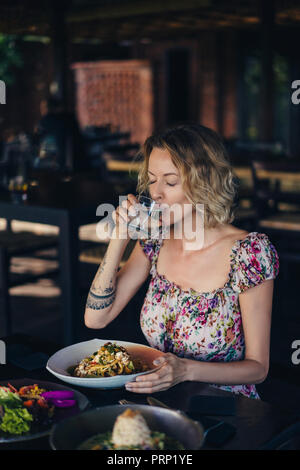 Portrait de femme de l'eau potable et avoir dîner dans le café