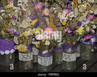 Fleurs séchées en pots de confiture pour tables de mariage Banque D'Images