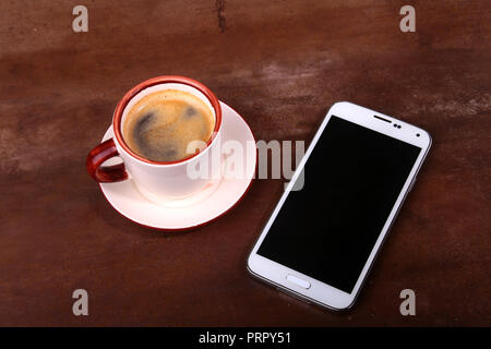 Tasse à café et smartphone sur table en bois. Vue de dessus Banque D'Images