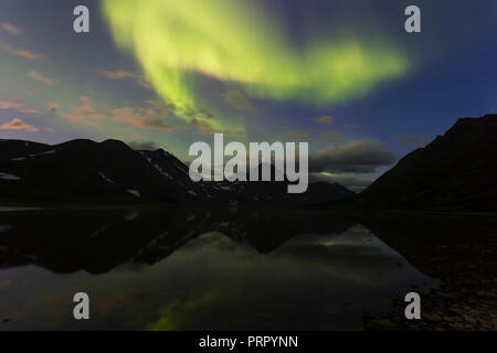 Aurora dans le ciel de nuit couper les montagnes, reflétée dans l'eau. Yamal. La Russie Banque D'Images