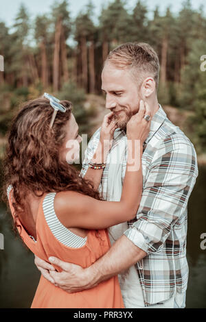 Homme barbu aux cheveux blonds feeing alors incroyable femme curly attrayants Banque D'Images