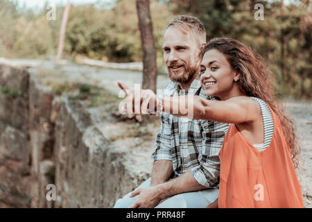 Couple d'homme aux cheveux blonds et bouclés femme radieuse assis près de l'ensemble du canyon Banque D'Images