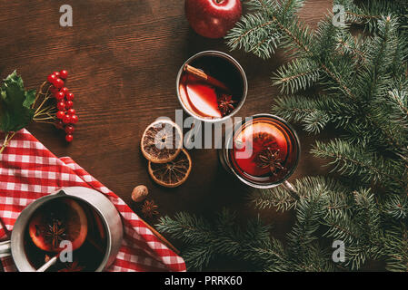 Vue du dessus du verre tasses chaudes faites maison avec vin épicé sur fond de bois avec des branches et les baies de la viorne Banque D'Images