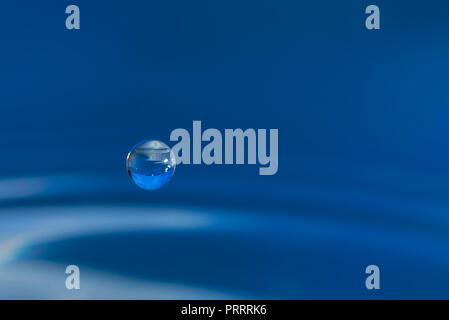 Des gouttelettes d'eau colorée de rebondir sur l'eau Banque D'Images