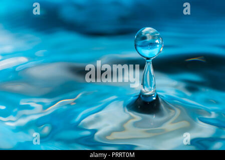 Des gouttelettes d'eau colorée de rebondir sur l'eau Banque D'Images