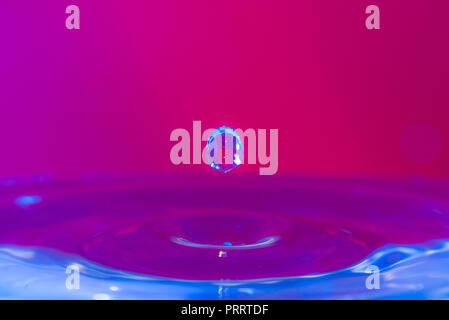 Des gouttelettes d'eau colorée de rebondir sur l'eau Banque D'Images