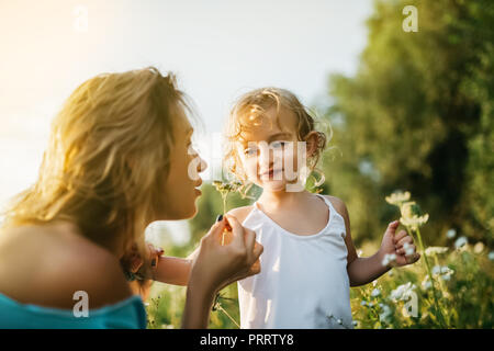 Mère d'essence de fleurs des champs, souriant à la fille à maman Banque D'Images