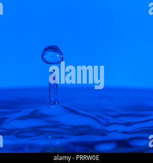Des gouttelettes d'eau colorée de rebondir sur l'eau Banque D'Images