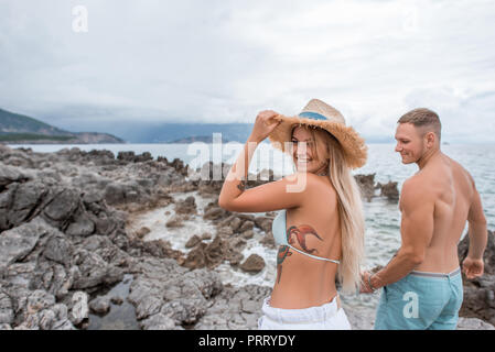 Happy young couple holding hands and walking on Rocky beach au Monténégro Banque D'Images