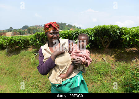 A smiling woman holding rwandais son bébé. Banque D'Images