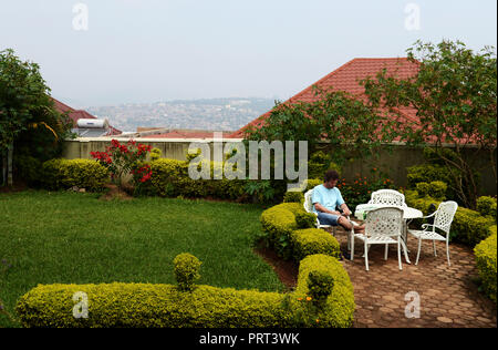 Un touriste se reposant dans le magnifique jardin de l'hôtel Yambi à Kigali. Banque D'Images