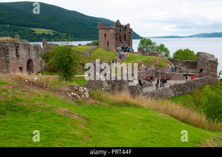 Les touristes visitant les ruines historiques de Urquhart Castle surplombant la vue sur le Loch Ness, en Ecosse Banque D'Images