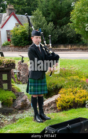 Jeune fille habillé en costume écossais jouer de la cornemuse pour gagner des dons des touristes en jouant à un haut lieu touristique en Ecosse Banque D'Images