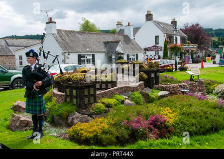 Jeune fille habillé en costume écossais jouer de la cornemuse pour gagner des dons des touristes en jouant à un haut lieu touristique en Ecosse Banque D'Images