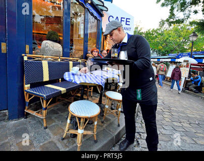 Paris, France. Waiter déblayer les tasses de café d'une table en place du Tertre, Montmartre Banque D'Images