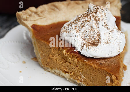 Tranche de tarte à la citrouille faits maison avec garniture et saupoudré d'épices pour tarte à la citrouille. L'extrême profondeur de champ avec l'accent sur la crème fouettée. Banque D'Images