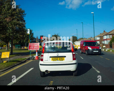 CA trois façon feu de circulation contrôlée à l'entrée de la route à voie unique travaillant au cours de travaux routiers inscription attendre ici jusqu'à ce que le témoin vert indique Banque D'Images