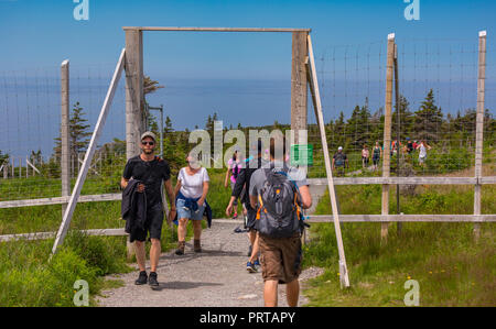 L'île du Cap-Breton, Nouvelle-Écosse, Canada - Les gens passent par la porte de clôture d'exclusion de l'orignal sur le sentier Skyline à Cape Breton Highlands National Park. Banque D'Images