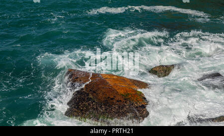 Rock en mer. Les vagues se brisant sur une plage de galets. Belle Mer vagues se briser contre les rochers de la plage de Leblon Rio de Janeiro, Brésil province Banque D'Images