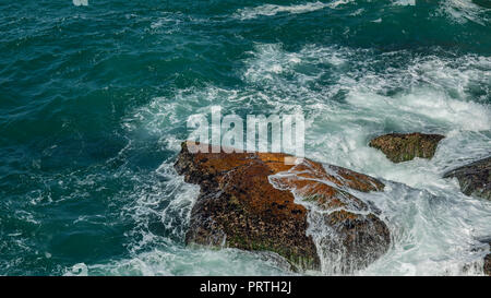 Rock en mer. Les vagues se brisant sur une plage de galets. Belle Mer vagues se briser contre les rochers de la plage de Leblon Rio de Janeiro, Brésil province Banque D'Images