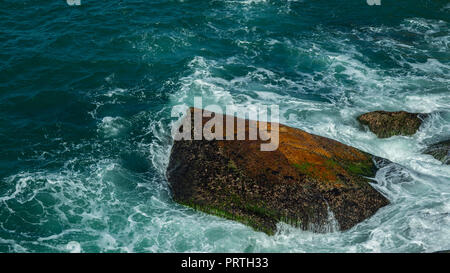 Rock en mer. Les vagues se brisant sur une plage de galets. Belle Mer vagues se briser contre les rochers de la plage de Leblon Rio de Janeiro, Brésil province Banque D'Images