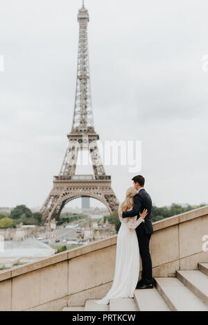 La mariée et du marié, de la Tour Eiffel en arrière-plan, Paris, France Banque D'Images