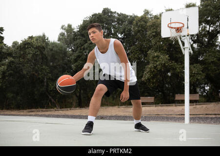 Les adolescents de sexe masculin de basket-ball jouant au basket-ball sur cour Banque D'Images