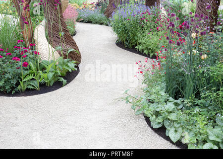 Jardin anglais moderne contemporain avec un chemin Gravel avec des bordures de fleurs mixtes Hampton court Flower Show England Banque D'Images
