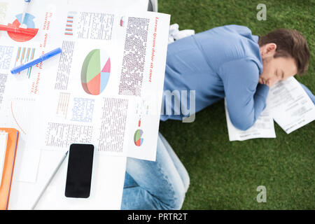 Young businessman sleeping on Green grass carpet au bureau moderne, établissement d'entreprise Banque D'Images