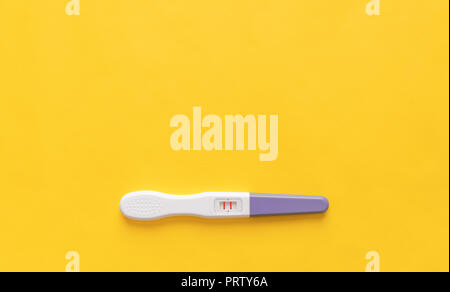Test de grossesse sur un fond jaune. Close-up. Banque D'Images