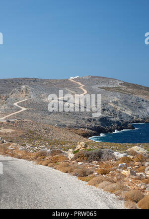 La côte rocheuse de Sifnos avec l'église d'Agios Georgios de Heronissos dans la distance. Banque D'Images