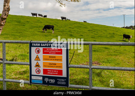 Avis de sécurité agricole sur une porte à un champ avec des vaches sur une journée ensoleillée à Ballydehob, West Cork, Irlande. Banque D'Images