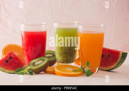 Rangée de kiwi, d'orange et de melon d'eau et diverses pièces de smoothie aux fruits sur fond de bois Banque D'Images