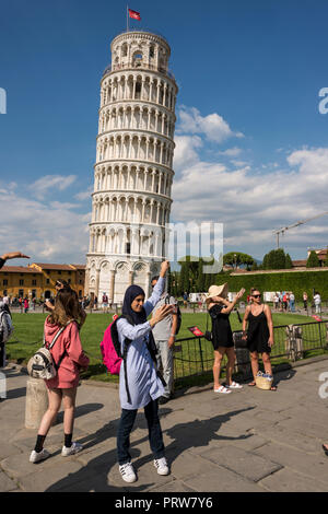 Une femme musulmane en touriste posant selfies contre la tour penchée de Pise, Toscane, Italie Banque D'Images