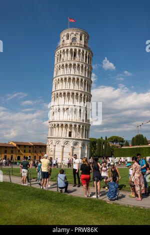 Tourist qui pose pour photo contre la tour penchée de Pise, Toscane, Italie Banque D'Images