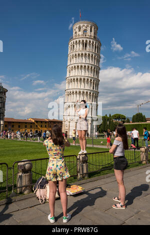 Tourist qui pose pour photo contre la tour penchée de Pise, Toscane, Italie Banque D'Images