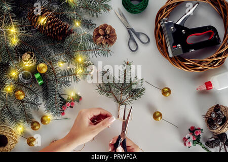 Fond de Noël avec des décorations, Garland et des pommes de pin. La création d'arbre de Noël de couronne de branches sur fond blanc. Banque D'Images