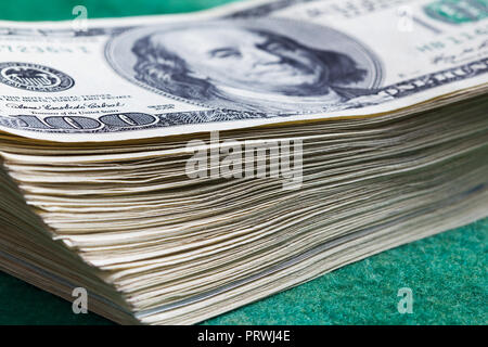 Pile de billets de cent dollars sur fond vert Banque D'Images