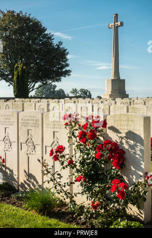 Prouvé, Flandre, Belgique - 15 septembre 2018 : le cimetière de guerre britannique à Mendinghem sous ciel bleu matin. Pelouse verte, beige des pierres tombales et r Banque D'Images