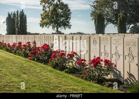 Prouvé, Flandre, Belgique - 15 septembre 2018 : rangée de pierres tombales au cimetière de guerre britannique Mendinghem sous ciel bleu matin. Pelouse verte et Banque D'Images