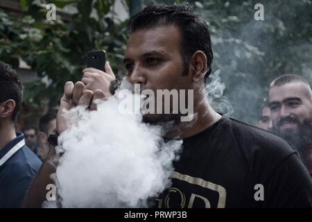 Athènes, Grèce. 4ème Oct, 2018. Un manifestant vu fumer cigarette de vapeur pendant la manifestation.Les gens de protestation devant le ministère de la santé, contre la circulaire du ministère de la santé qui interdit la vente de cigarettes de vapeur Crédit : Giorgos Zachos/SOPA Images/ZUMA/Alamy Fil Live News Banque D'Images