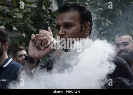 Athènes, Grèce. 4ème Oct, 2018. Un manifestant vu fumer cigarette de vapeur pendant la manifestation.Les gens de protestation devant le ministère de la santé, contre la circulaire du ministère de la santé qui interdit la vente de cigarettes de vapeur Crédit : Giorgos Zachos/SOPA Images/ZUMA/Alamy Fil Live News Banque D'Images