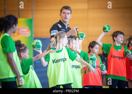 05 octobre 2018, Berlin : Christian Prokop (M), entraîneur de handball nationale, mène un programme de formation avec des élèves de l'école primaire Am Faulen Voir. L'école primaire de Berlin avait gagné un cours de formation de handball avec l'entraîneur national Prokop dans un projet d'école nationale de la Fédération allemande de Handball (DHB) et l'AOK. Avec ce projet, les deux partenaires veulent motiver les enfants pour plus d'exercice et de handball. Photo : Arne Immanuel Bänsch/dpa Banque D'Images
