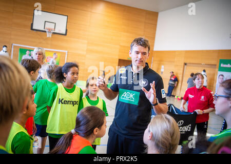 05 octobre 2018, Berlin : Christian Prokop (M), entraîneur de handball nationale, mène un programme de formation avec des élèves de l'école primaire Am Faulen Voir. L'école primaire de Berlin avait gagné un cours de formation de handball avec l'entraîneur national Prokop dans un projet d'école nationale de la Fédération allemande de Handball (DHB) et l'AOK. Avec ce projet, les deux partenaires veulent motiver les enfants pour plus d'exercice et de handball. Photo : Arne Immanuel Bänsch/dpa Banque D'Images